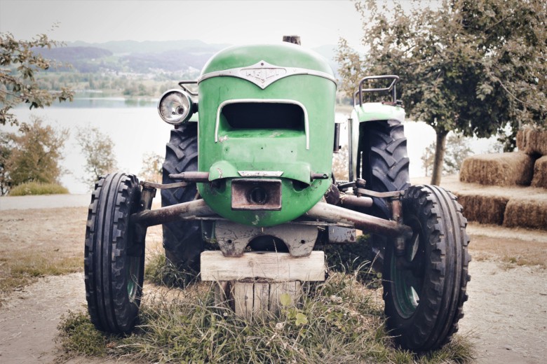 Old green tractor in a field